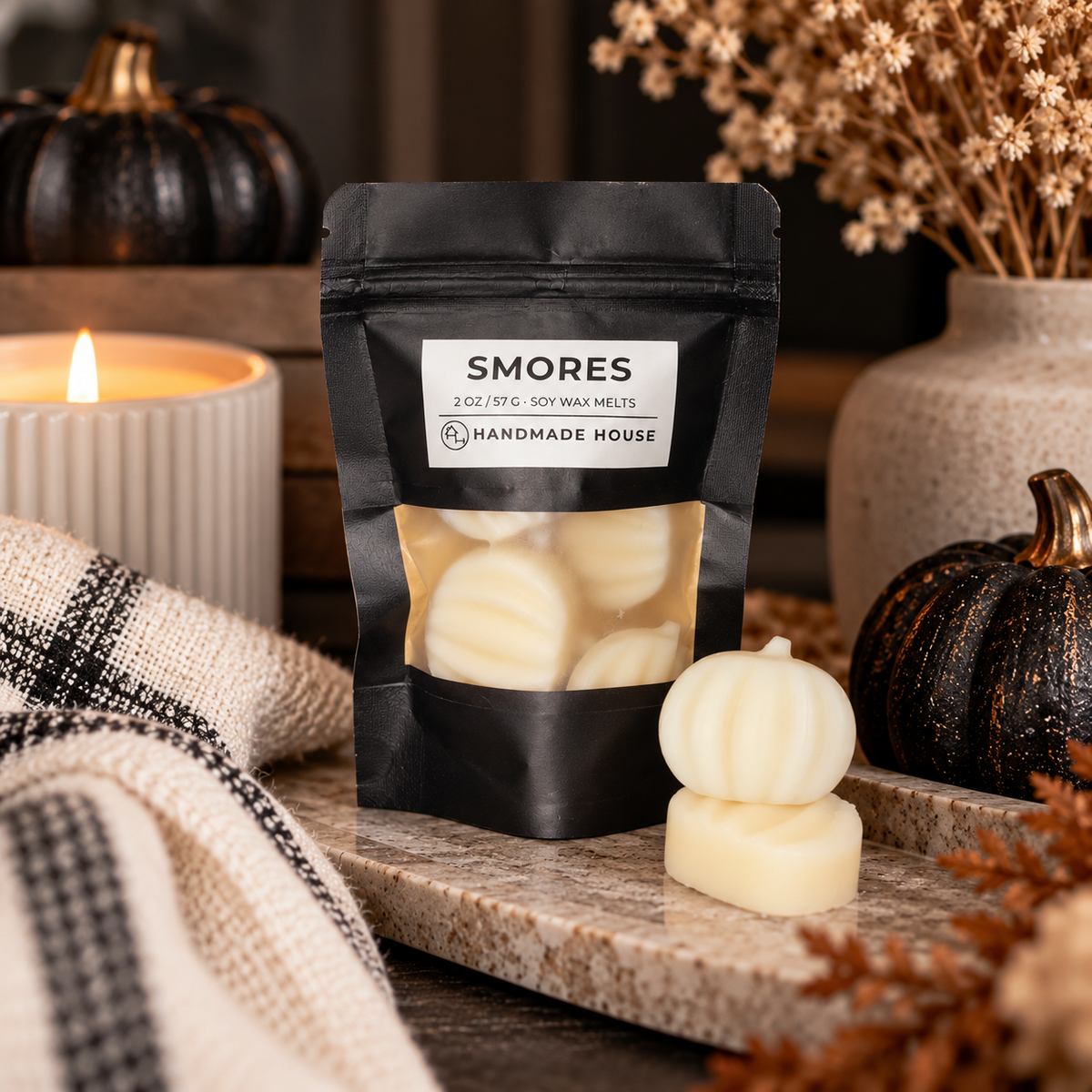S'mores 2 oz soy wax melts in pumpkin shapes beside a jack-o'-lantern