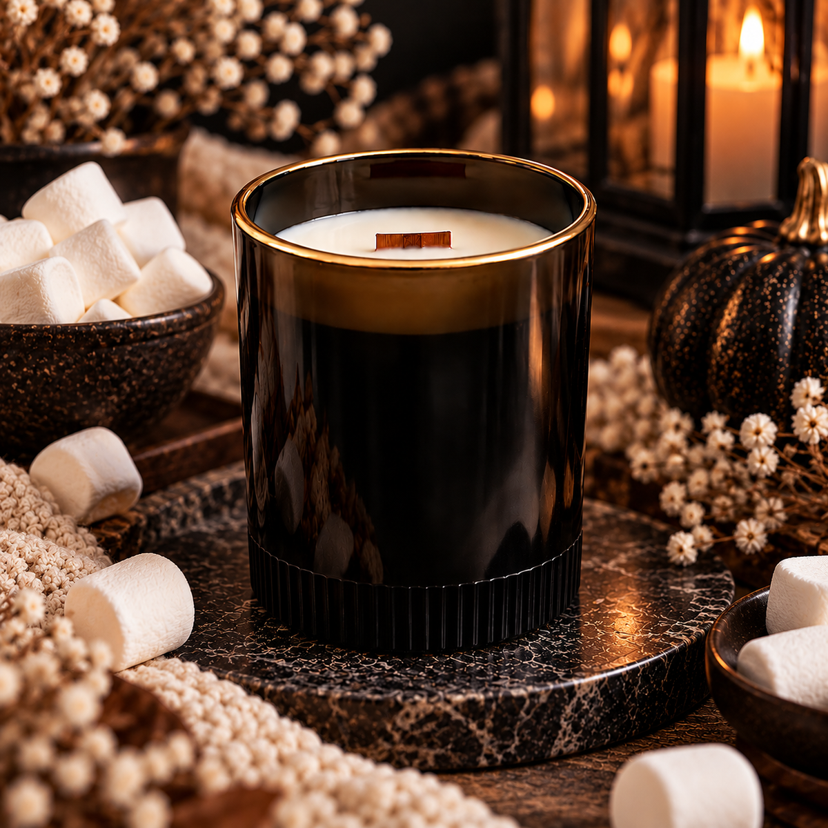 Black ribbed soy candle surrounded by marshmallows in a cozy Halloween scene