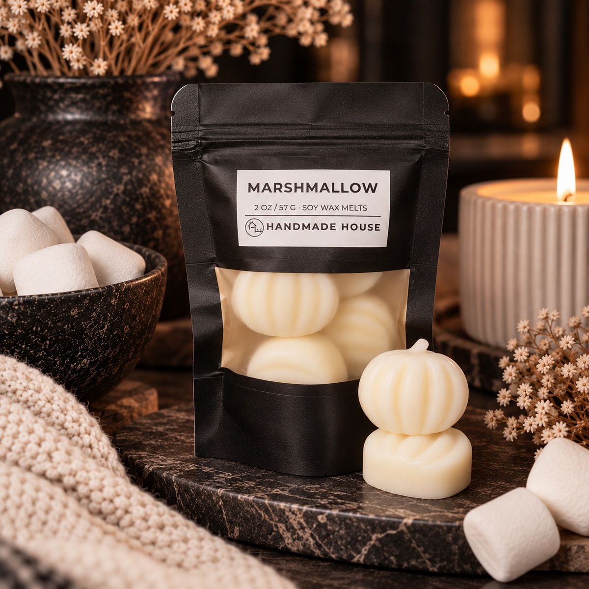Marshmallow soy wax melts in pumpkin shapes beside a black 2 oz pouch