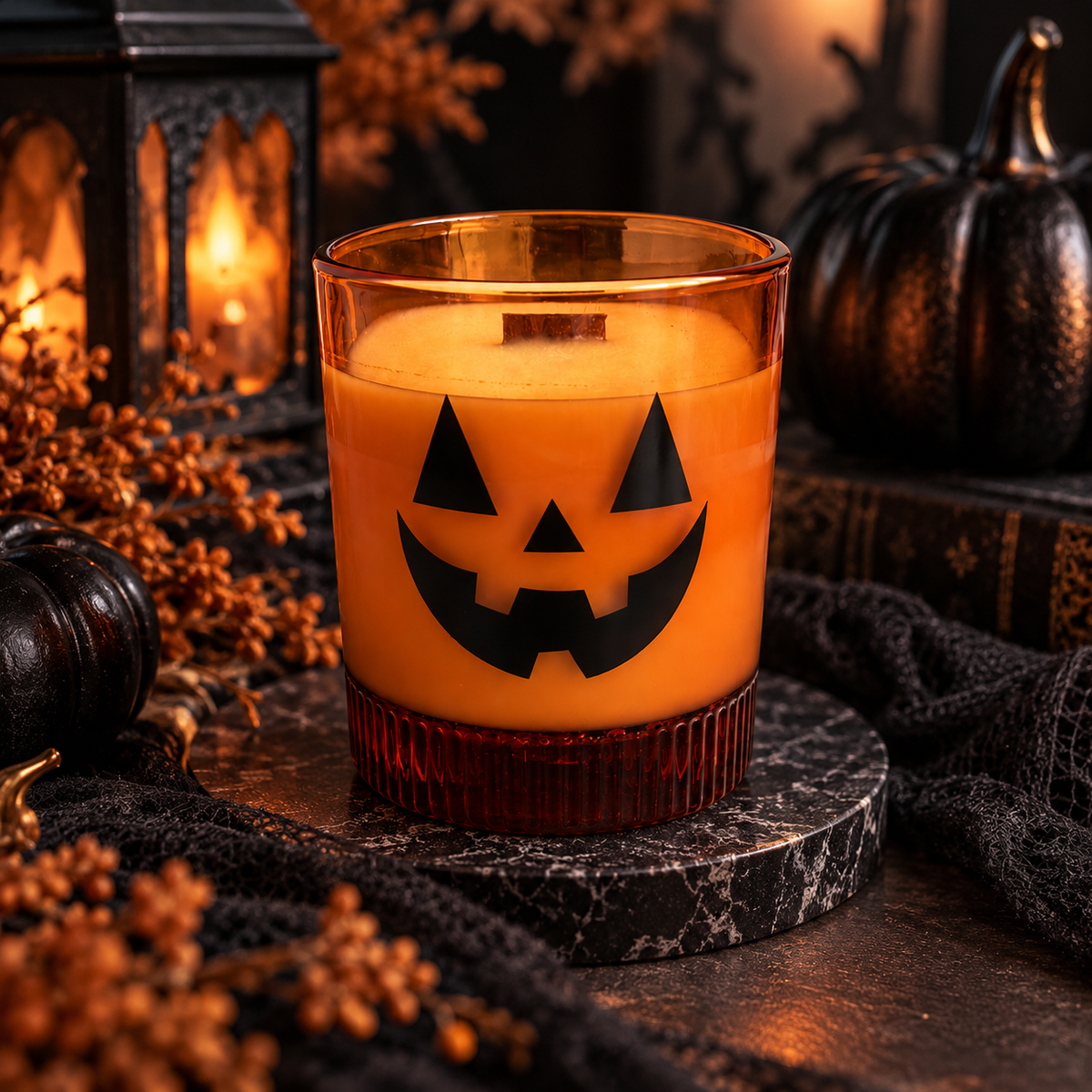 Orange jack-o'-lantern soy candle in a warm spooky-season display