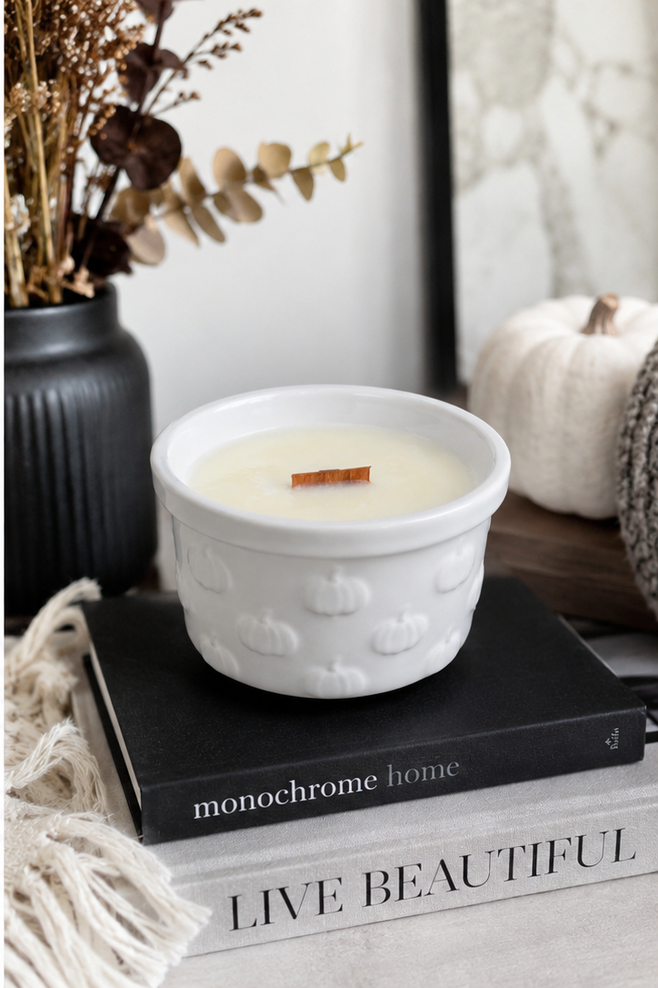 Pumpkin Pie Soy Candle in white ceramic pumpkin-embossed bowl on stacked books with fall decor